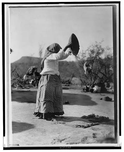 Papago cleaning wheat (Winnowing wheat), Arizona, 1907