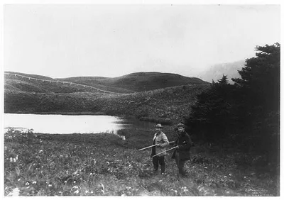 [Two men with guns in foreground, pond and mountain in background,…, 1899