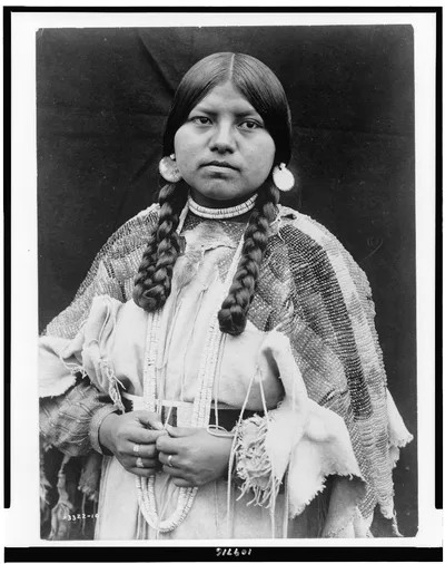 [Cayuse woman, half-length portrait, standing, facing front, braids,…, 1910